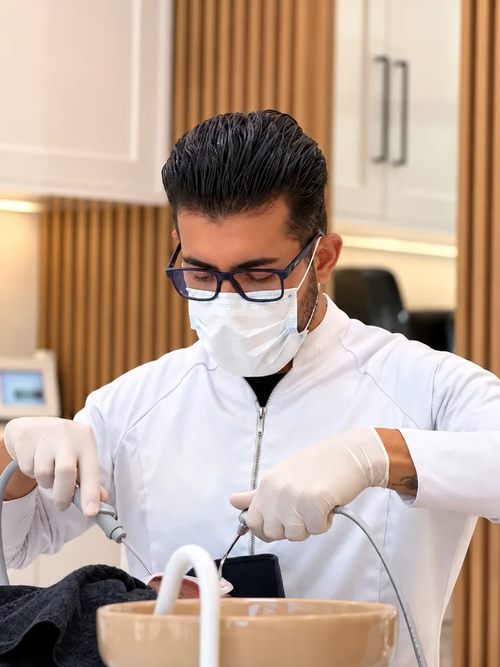 Dr. Marcos trabalhando durante um procedimento odontológico.